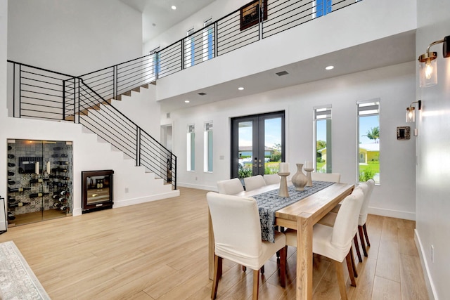 12952 Drayton Rd, North Palm Beach, FL 33408 - dining area featuring light wood finished floors, baseboards, french doors, and stairs