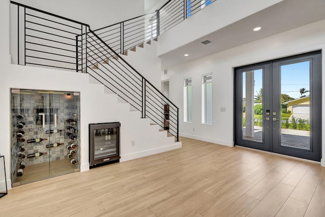 12952 Drayton Rd, North Palm Beach, FL 33408 - entryway featuring wood finished floors, french doors, baseboards, wine cooler, and stairs