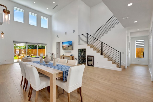 12952 Drayton Rd, North Palm Beach, FL 33408 - dining area with baseboards, a towering ceiling, a healthy amount of sunlight, and stairs