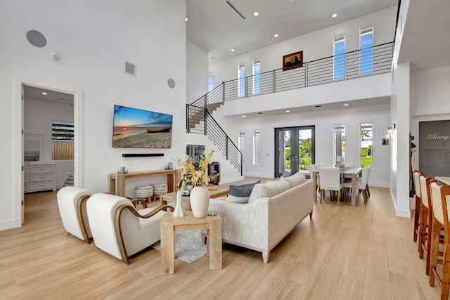 12952 Drayton Rd, North Palm Beach, FL 33408 - living area with light wood finished floors, a towering ceiling, stairs, and baseboards
