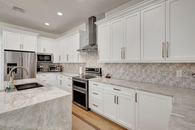 12952 Drayton Rd, North Palm Beach, FL 33408 - kitchen with a sink, visible vents, wall chimney exhaust hood, white cabinetry, and appliances with stainless steel finishes