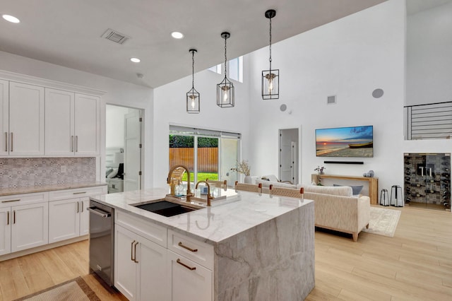12952 Drayton Rd, North Palm Beach, FL 33408 - kitchen with a sink, a towering ceiling, visible vents, dishwasher, and light stone countertops