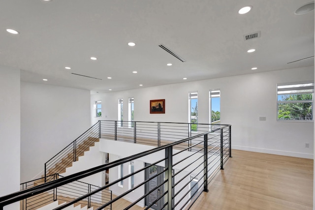12952 Drayton Rd, North Palm Beach, FL 33408 - hallway featuring light wood-type flooring, baseboards, a healthy amount of sunlight, and visible vents