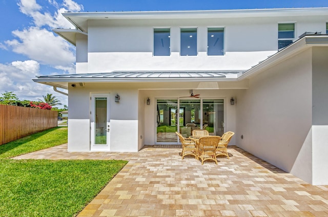 12952 Drayton Rd, North Palm Beach, FL 33408 - rear view of property with stucco siding, fence, metal roof, a patio area, and a standing seam roof
