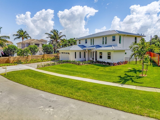 12952 Drayton Rd, North Palm Beach, FL 33408 - view of front of home with fence, concrete driveway, a front yard, metal roof, and a standing seam roof