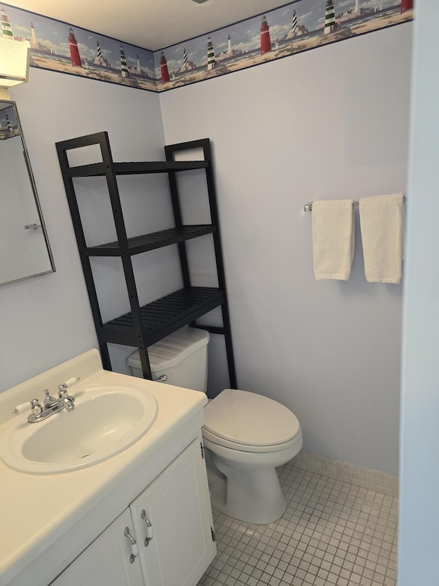 bathroom featuring toilet, baseboards, tile patterned floors, and vanity
