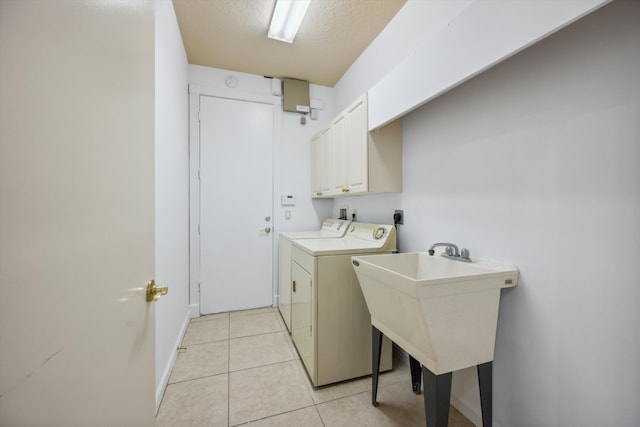4065 Manchester Lake Dr, Lake Worth, FL 33449 - laundry room with cabinet space, separate washer and dryer, light tile patterned floors, baseboards, and a textured ceiling