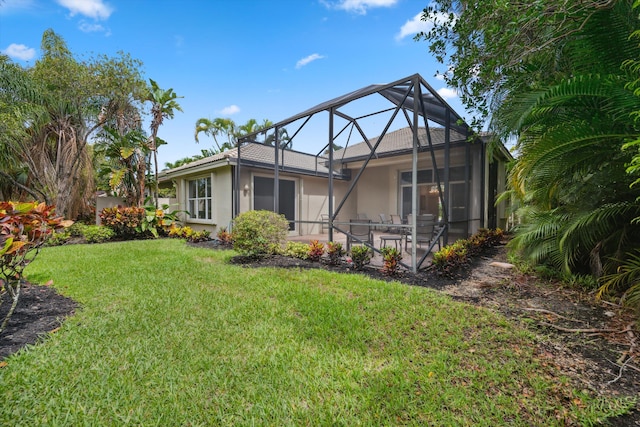 4065 Manchester Lake Dr, Lake Worth, FL 33449 - back of property with stucco siding, a patio, a lawn, and a lanai