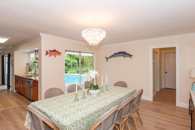 dining space featuring crown molding, a notable chandelier, light wood-type flooring, and baseboards