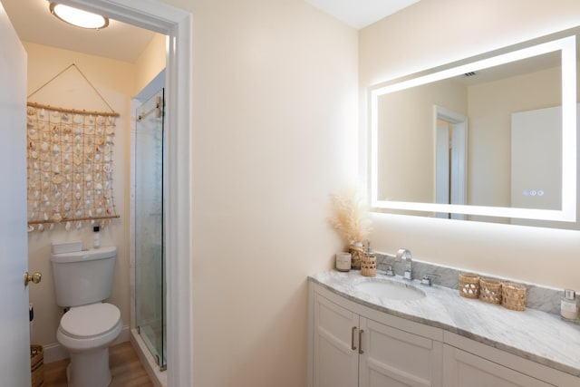 full bath featuring toilet, vanity, and a shower with shower door