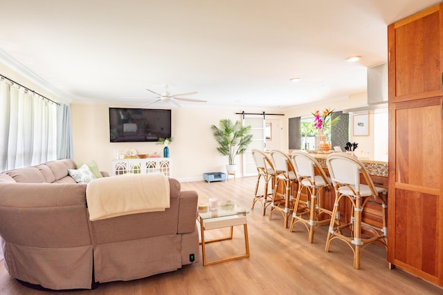 living room featuring a ceiling fan, light wood-style floors, and crown molding