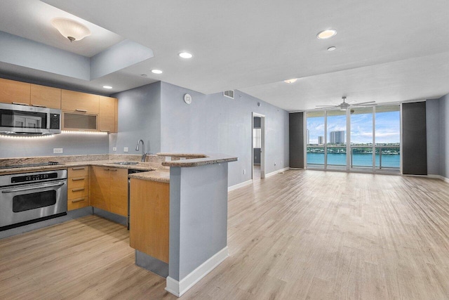 2640 Lake Shore Dr Unit 614, Riviera Beach, FL 33404 - kitchen featuring stainless steel appliances, open floor plan, a sink, a peninsula, and baseboards