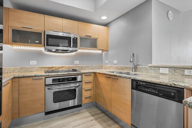 2640 Lake Shore Dr Unit 614, Riviera Beach, FL 33404 - kitchen featuring stainless steel appliances, a sink, light wood-style flooring, light stone counters, and light brown cabinetry