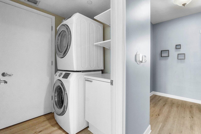 2640 Lake Shore Dr Unit 614, Riviera Beach, FL 33404 - laundry area with estacked washer and dryer, light wood-style flooring, and baseboards