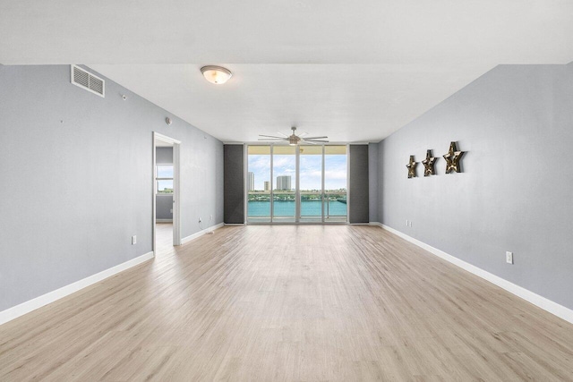 2640 Lake Shore Dr Unit 614, Riviera Beach, FL 33404 - unfurnished room featuring a wall of windows, light wood-type flooring, ceiling fan, and baseboards