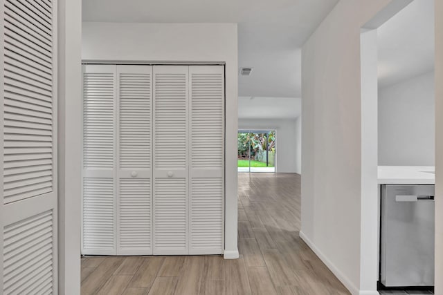 hallway featuring wood finished floors and baseboards