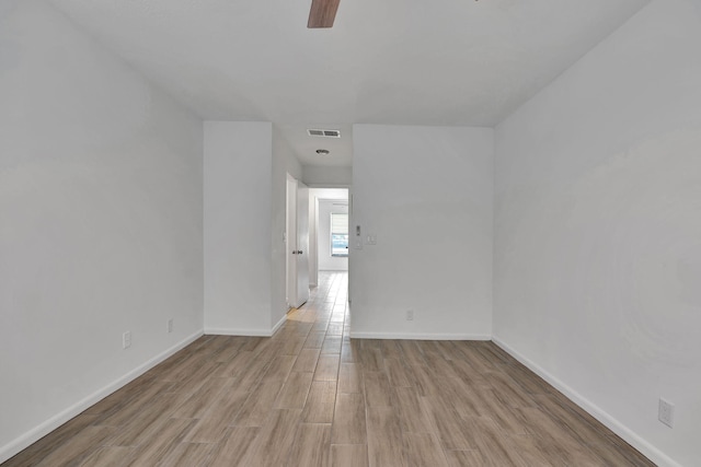 spare room featuring a ceiling fan, wood finished floors, and baseboards