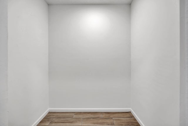 unfurnished room with baseboards and wood tiled floors