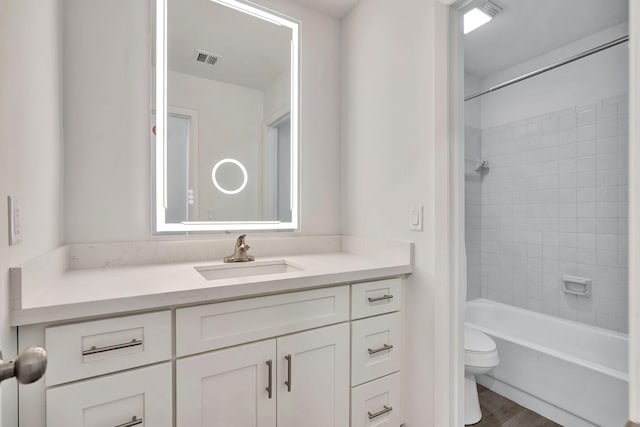 full bath with toilet, vanity, wood finished floors, and shower / bath combination