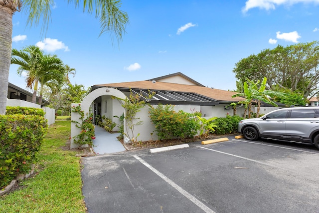 13801 Royal Palm Ct Unit A, Delray Beach, FL 33484 - view of front of house featuring stucco siding, fence, and uncovered parking