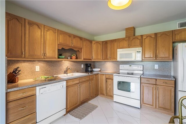 3215 S Lakeview Cir Unit 12104, Hutchinson Island, FL 34949 - kitchen with white appliances, a sink, decorative backsplash, and brown cabinetry
