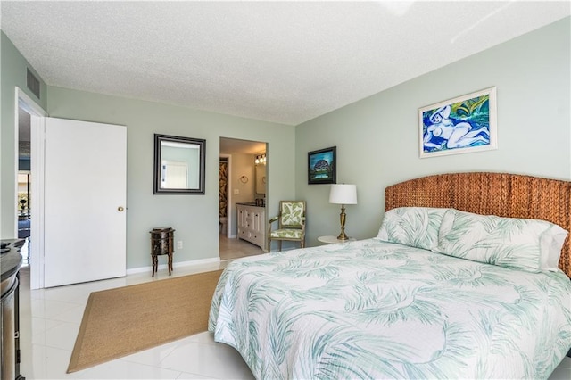 3215 S Lakeview Cir Unit 12104, Hutchinson Island, FL 34949 - bedroom featuring tile patterned flooring, a textured ceiling, and ensuite bath