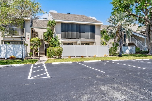 3215 S Lakeview Cir Unit 12104, Hutchinson Island, FL 34949 - view of property with stairs, uncovered parking, and fence