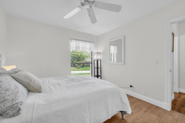 bedroom featuring wood finished floors, baseboards, and ceiling fan
