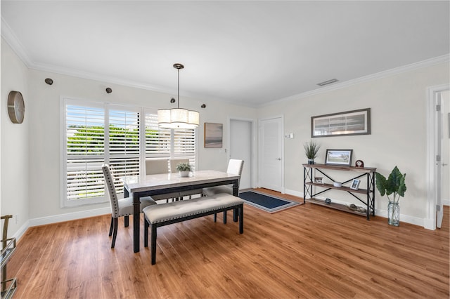 dining space with light wood-style flooring, baseboards, and ornamental molding