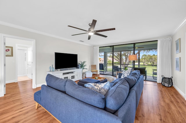 living room with ceiling fan, crown molding, light wood finished floors, and baseboards