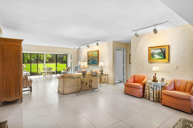 living area featuring track lighting, light tile patterned flooring, and a textured ceiling