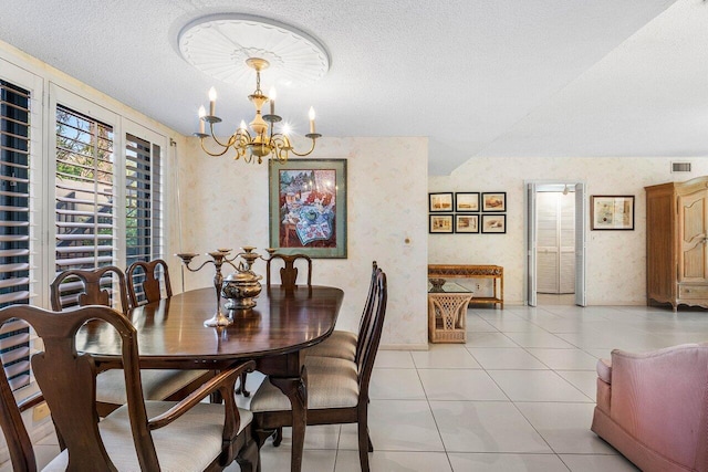 dining area with a chandelier, a textured ceiling, and light tile patterned floors