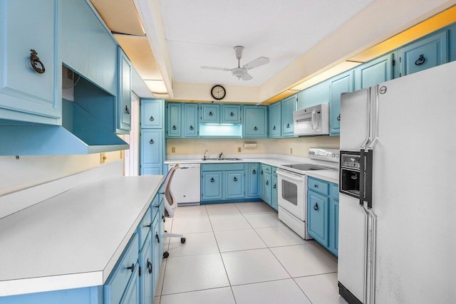 kitchen featuring white appliances, blue cabinetry, a sink, a ceiling fan, and light countertops