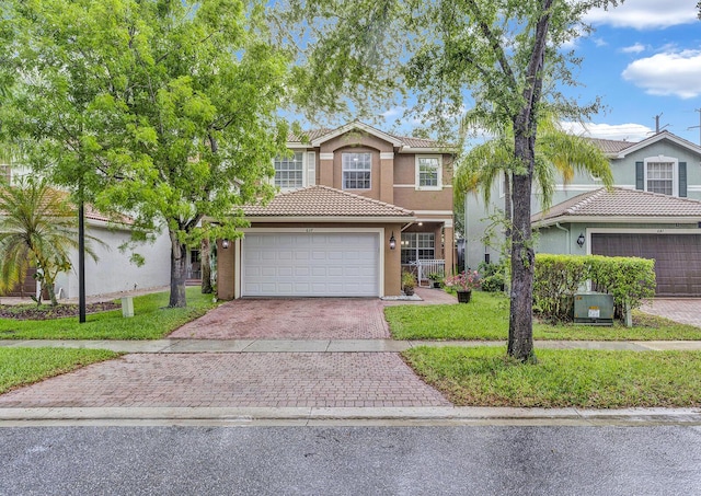 traditional home with decorative driveway, stucco siding, a tile roof, a garage, and a front lawn