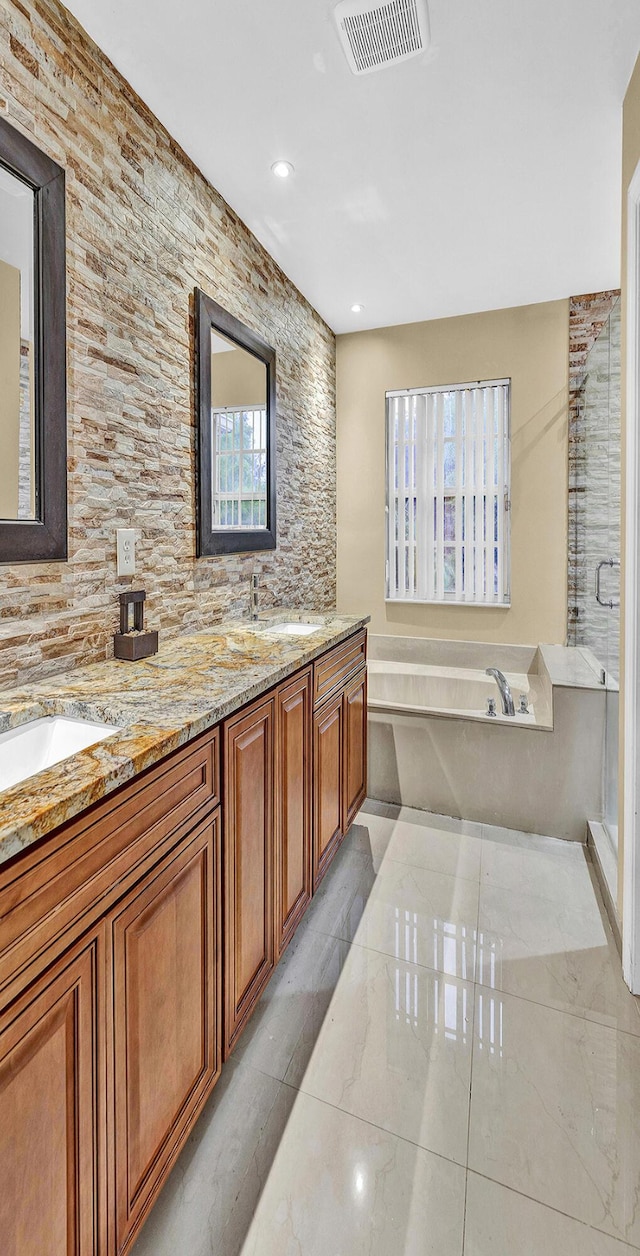 bathroom with a bath, a stall shower, double vanity, backsplash, and recessed lighting