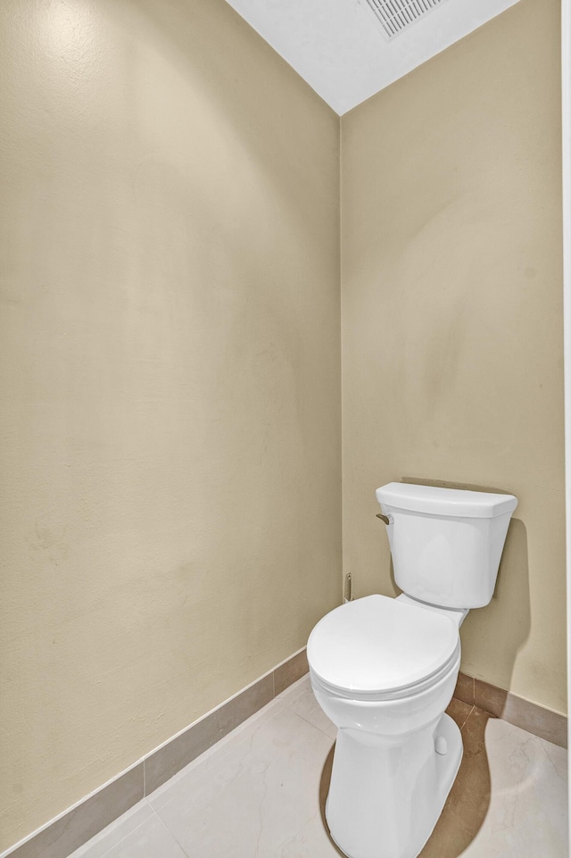 bathroom with baseboards and toilet