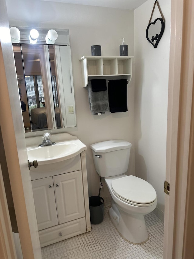 ensuite bathroom with vanity, toilet, ensuite bathroom, and tile patterned floors