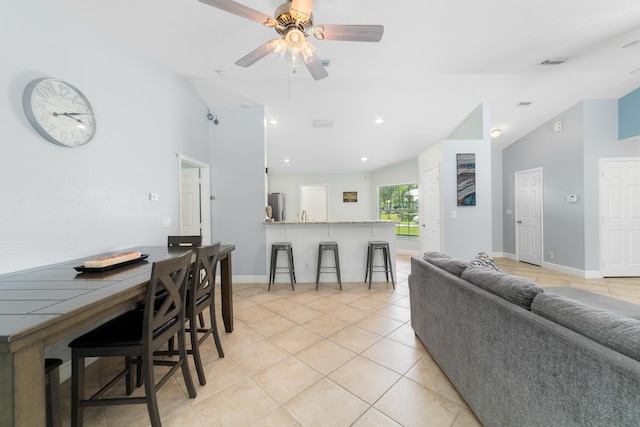 living room with vaulted ceiling, light tile patterned floors, ceiling fan, and baseboards