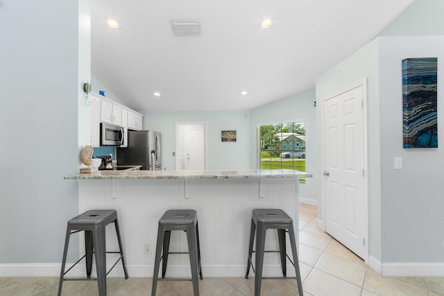 kitchen with stainless steel appliances, a peninsula, baseboards, and recessed lighting