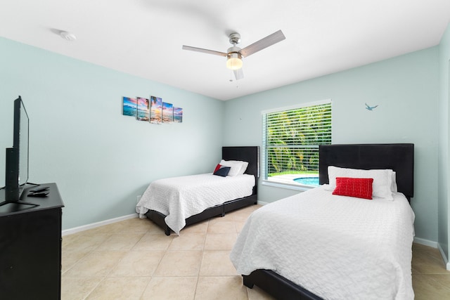 bedroom featuring light tile patterned floors, baseboards, and a ceiling fan