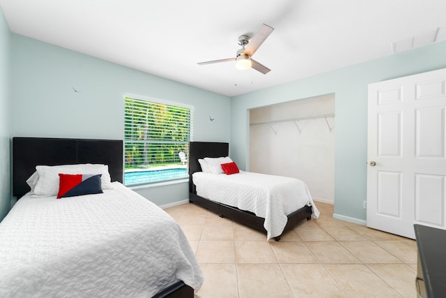 bedroom with light tile patterned floors, a ceiling fan, baseboards, and a closet