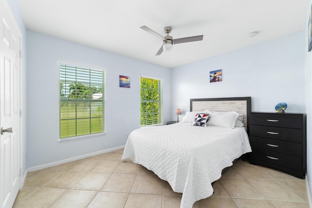 bedroom featuring light tile patterned flooring, ceiling fan, and baseboards
