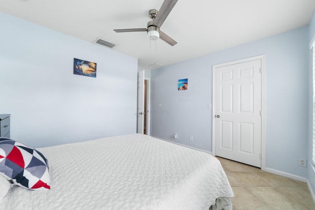 bedroom featuring baseboards, light tile patterned flooring, and a ceiling fan