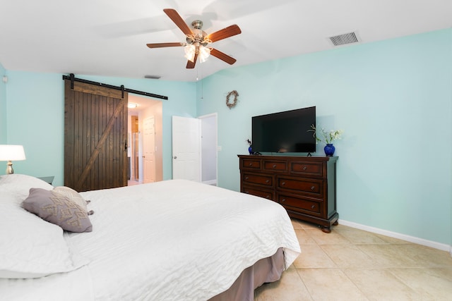bedroom featuring a barn door, baseboards, light tile patterned floors, and ceiling fan