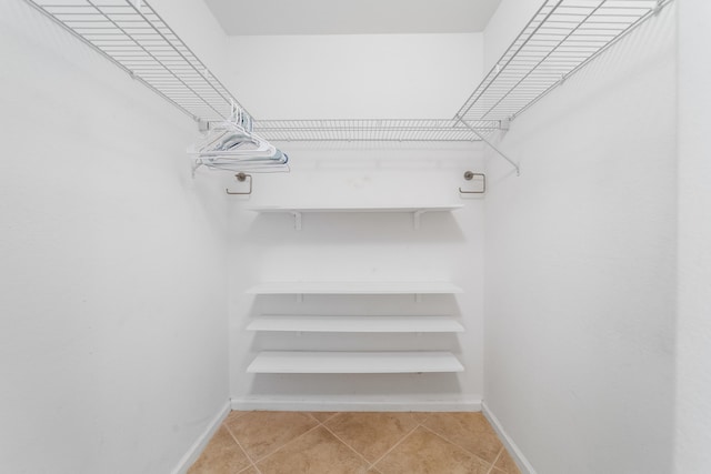 walk in closet with light tile patterned floors