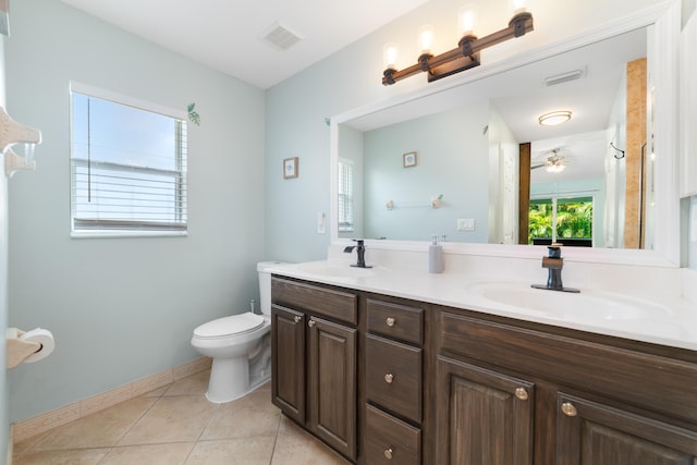 full bath with toilet, tile patterned floors, double vanity, a ceiling fan, and baseboards
