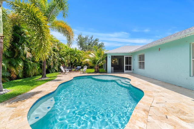 outdoor pool featuring a patio and a sunroom