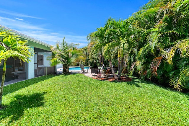 view of grassy yard with an outdoor pool and a patio
