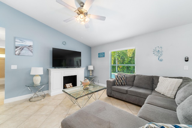 living room featuring vaulted ceiling, light tile patterned floors, ceiling fan, baseboards, and a fireplace
