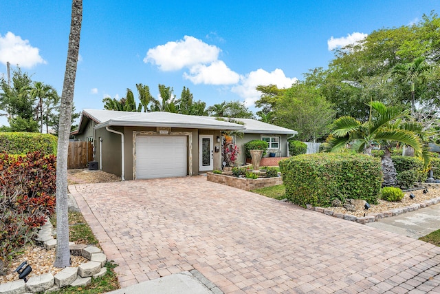 1707 NW 38th St, Oakland Park, FL 33309 - ranch-style house with fence, a garage, stucco siding, and decorative driveway